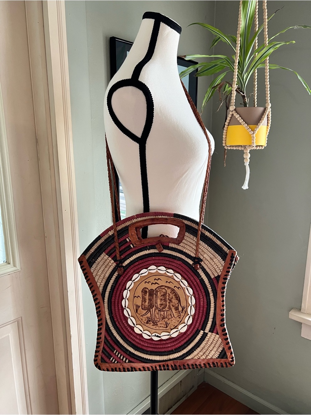 Handcrafted African shoulder
Bag with elephant etching and cowrie shells.